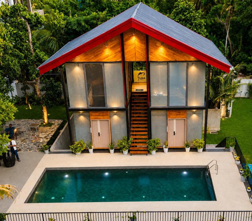a house with a swimming pool in front of it at TUNA Hiriketiya - Luxury Resort & Pool Retreat in Hiriketiya