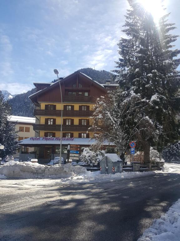 a large building with snow in front of it at Hotel Pineta in Ponte di Legno
