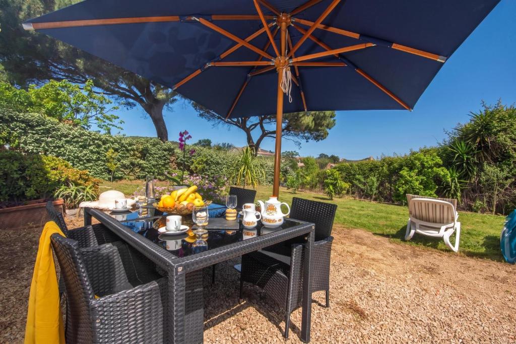 a table with food on it under an umbrella at La Sciumara with beach access - Happy Rentals in Cannigione