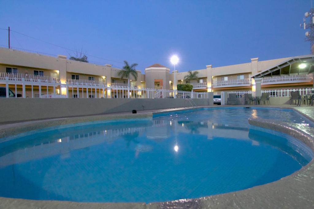a large swimming pool in front of a building at Hotel Premier in Hermosillo
