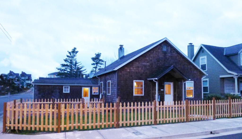 a small house with a wooden fence in front of it at Karr Beach House on Franklin in Seaside
