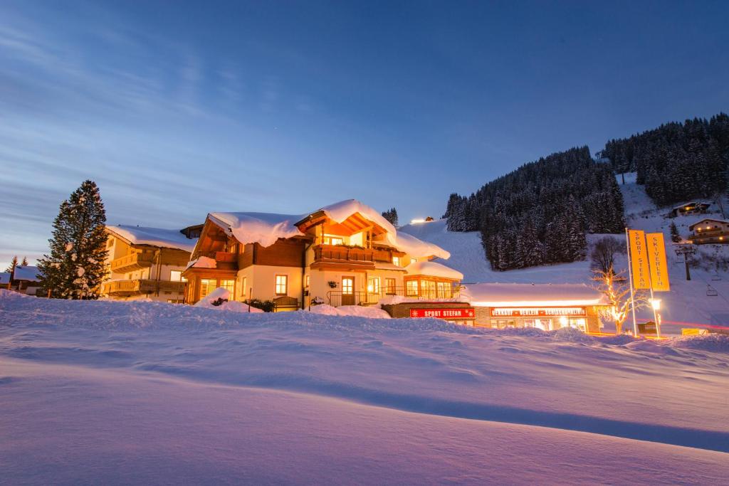 ein großes Haus im Schnee in der Nacht in der Unterkunft Landhaus Kainhof in Filzmoos