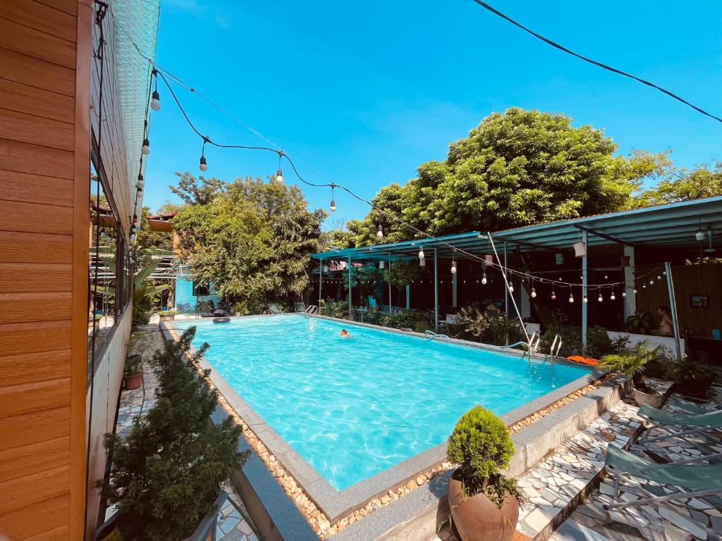 a swimming pool next to a building at Hideaway Village Homestay in Xuân Sơn