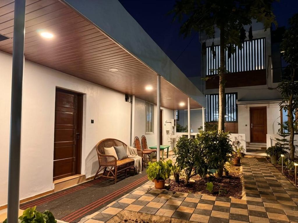 a patio of a house with chairs and a table at Tranquil Tents in Trivandrum