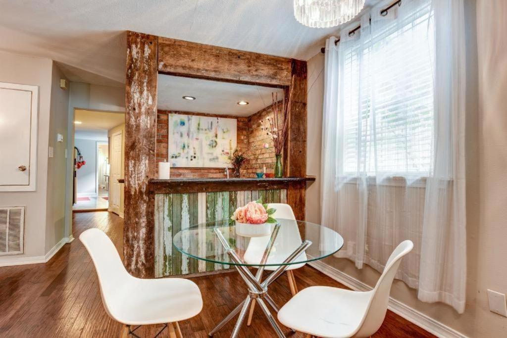 a dining room with a glass table and white chairs at Steps into the French Quarter in New Orleans