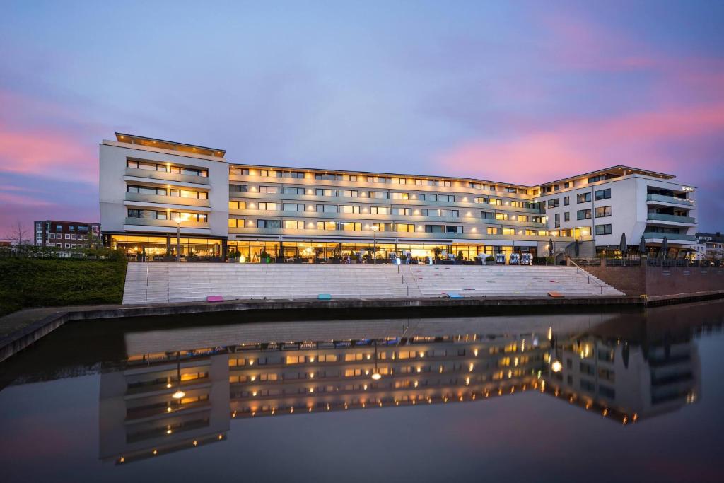 a building with a reflection in a body of water at elaya hotel kleve, Trademark Collection by Wyndham in Kleve