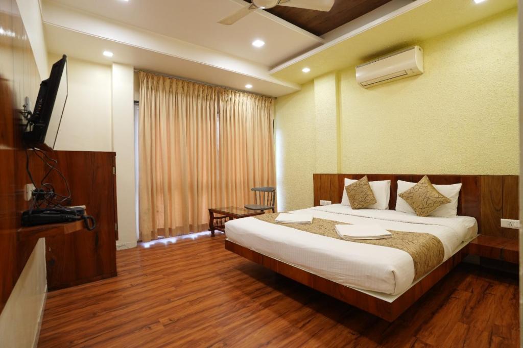 a hotel room with a bed and a television at Hotel Madhuri Executive in Kolhapur