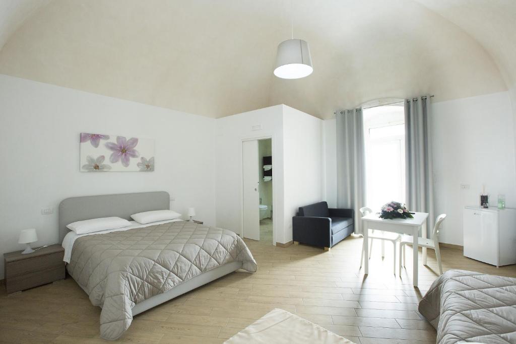 een witte slaapkamer met een bed en een bureau bij b&b San Nicandro in Sannicandro di Bari