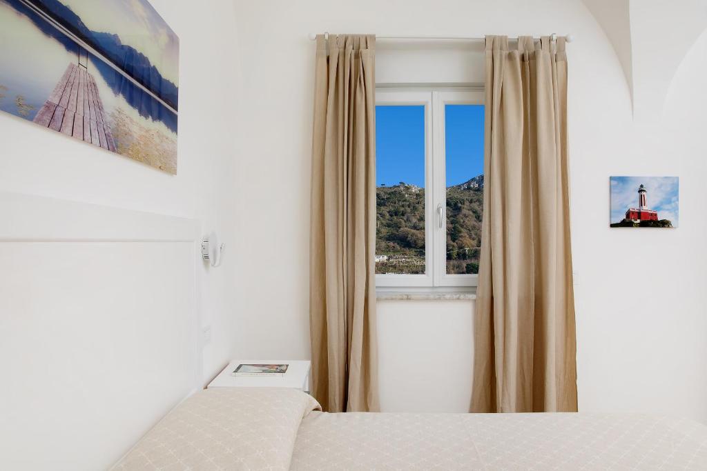 a bedroom with a bed and a window at Villa Pollio Guest House in Anacapri