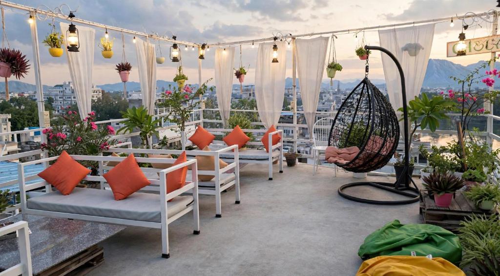 a balcony with chairs and flowers and lights at Raahi Backpacker's Hostel- Lake View in Udaipur