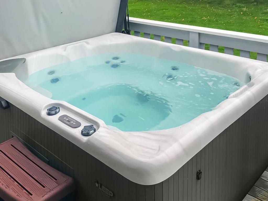 a large bath tub with blue water in it at Chestnut Cottage - Uk48294 in Great Yarmouth