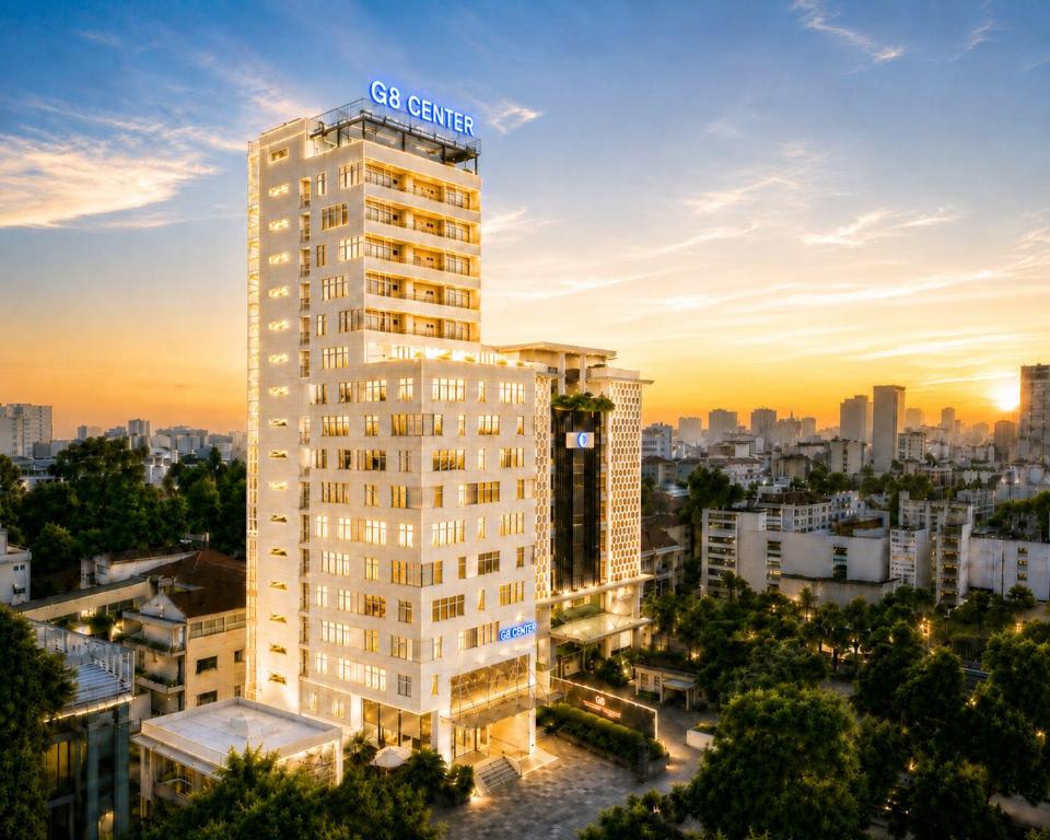 a tall white building with a sign on top of it at G8 Center Hotel Saigon in Ho Chi Minh City