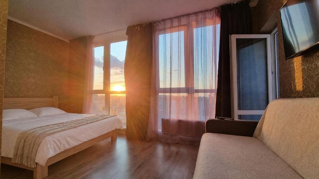 a bedroom with a bed and a large window at Apart with Panorama View Позняки Харьковская in Kyiv