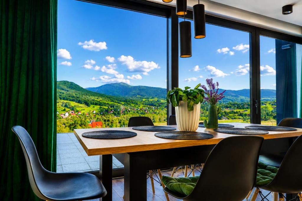 a dining room with a table and chairs and a large window at Beskid Island in Dobra