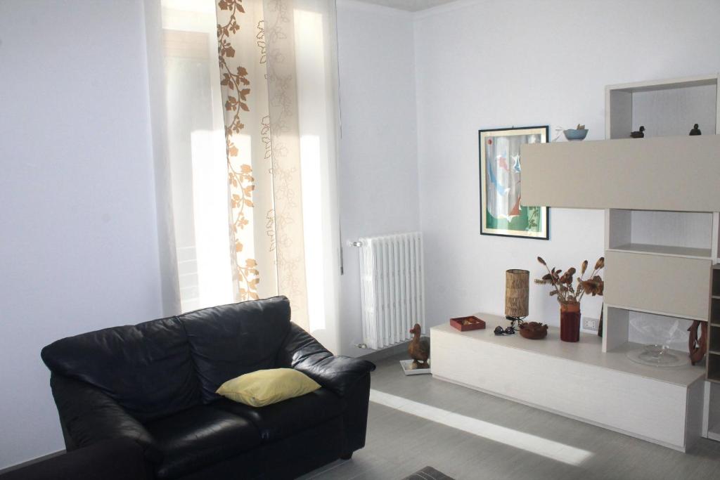 ein Wohnzimmer mit einem schwarzen Ledersessel und einem Fenster in der Unterkunft La Casa Di Nina in Matera