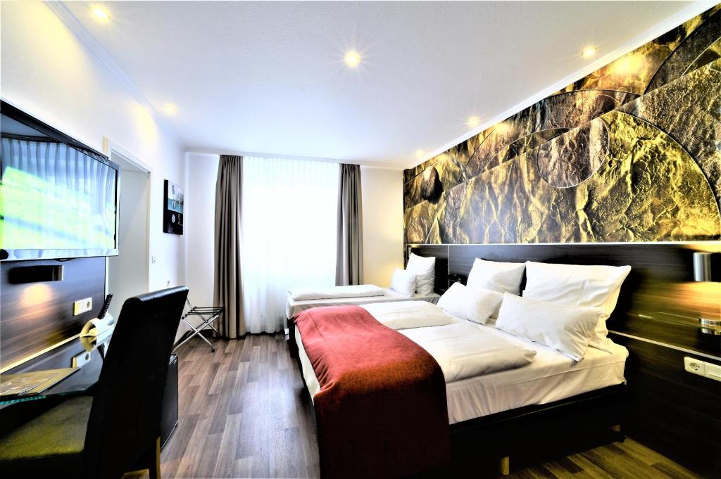 a hotel room with a bed and a tv at Ascot Hotel in Remscheid