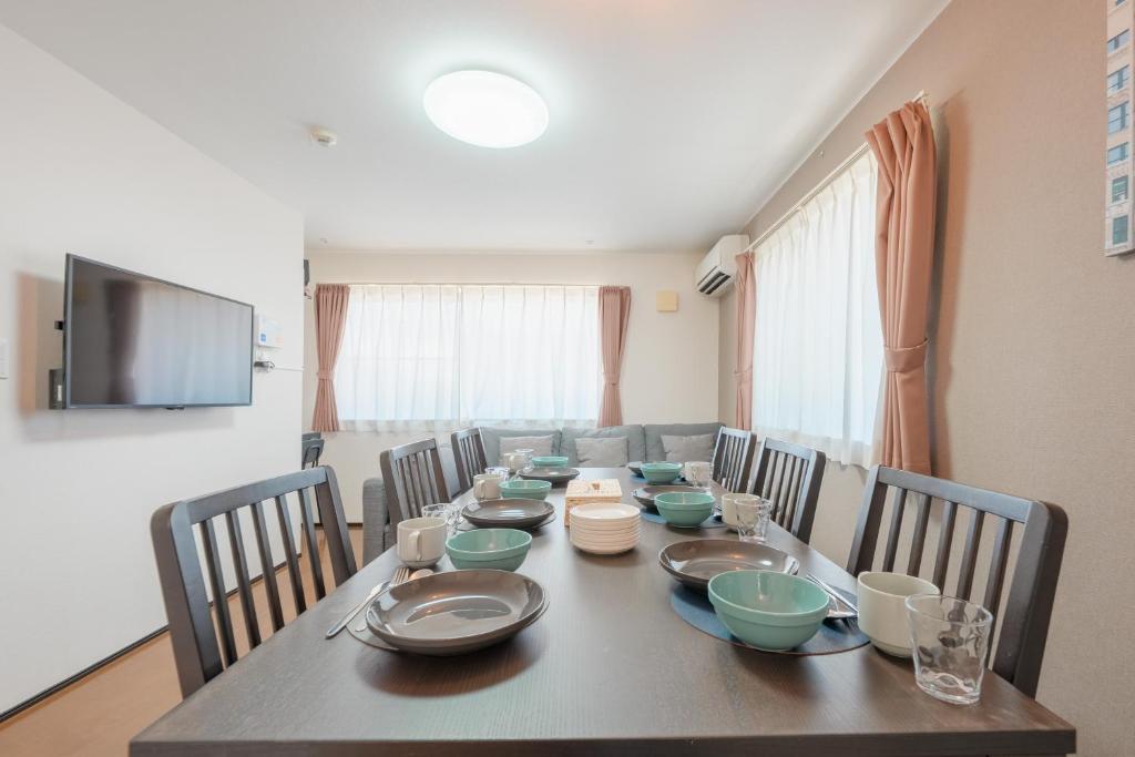 a dining room with a long table with chairs at FUJIMI TOWN HOUSE in Tokyo