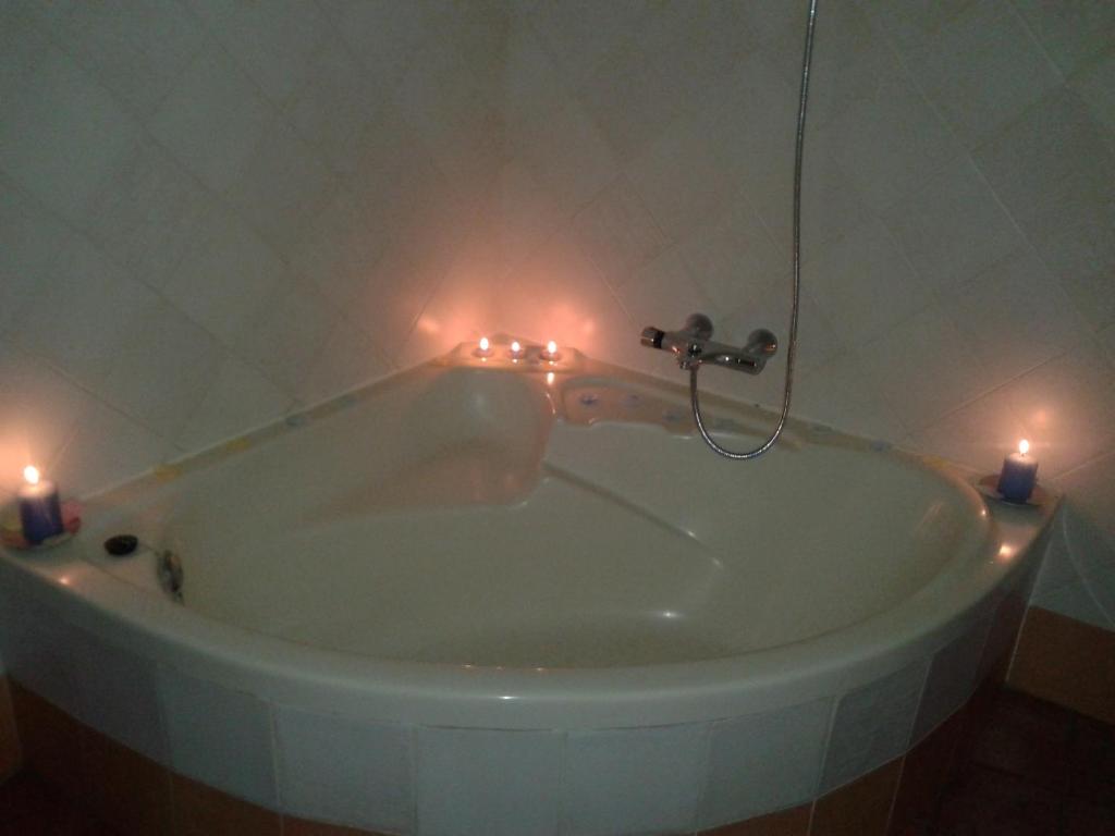 a bathroom with a tub with candles in it at El Cerrillo 1 in San Martín del Pimpollar