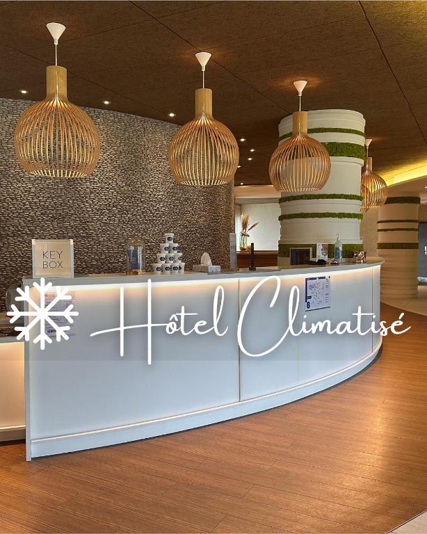 a restaurant with a counter with chandeliers at Brit Hotel & Spa Saint Brieuc Plérin in Plérin