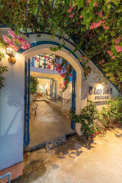 an entrance to a building with flowers on the ceiling at Lazy Bear Villa By The Little Hoi An in Hoi An