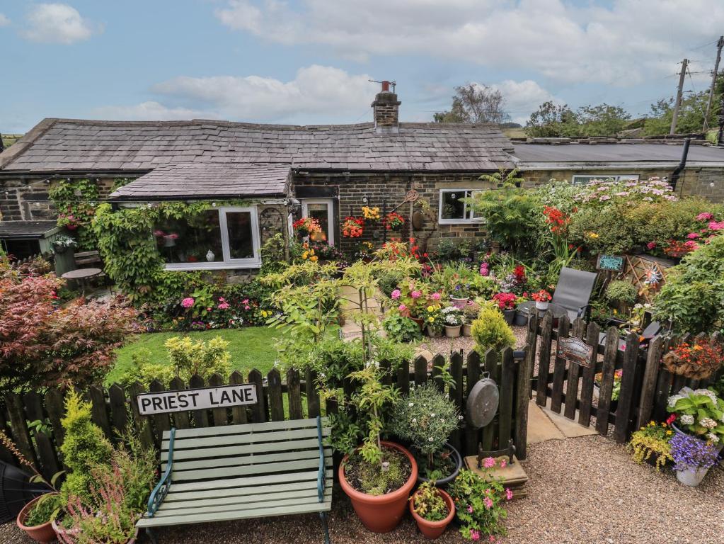 a house with a bunch of plants in front of it at Prospect Cottage in Sowerby Bridge
