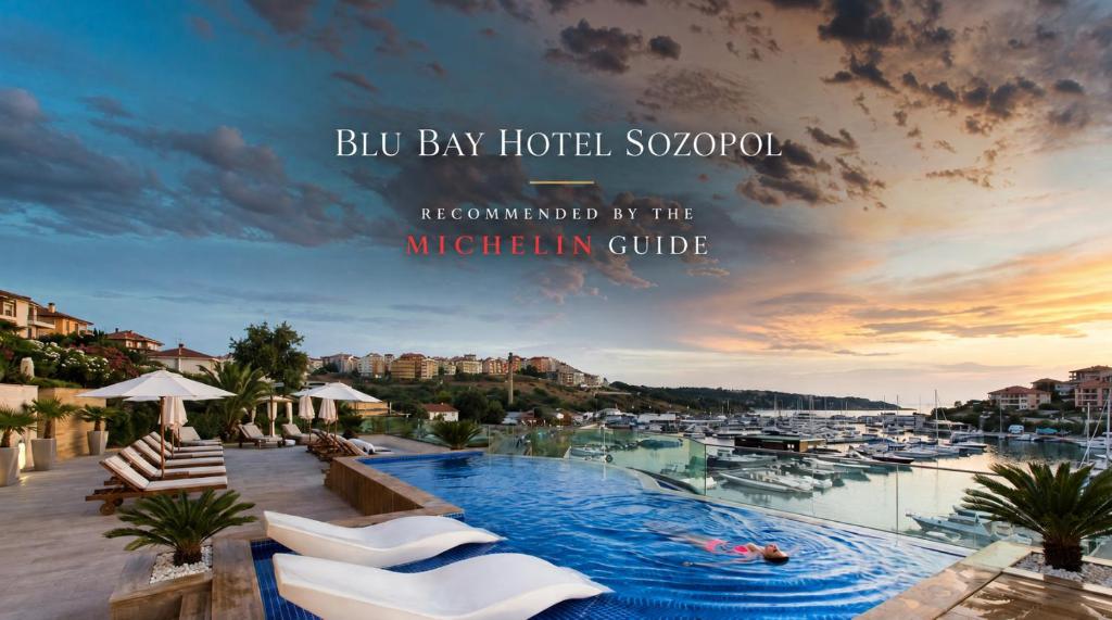 a large swimming pool with white chairs and a marina at Blu Bay Hotel Sozopol in Sozopol