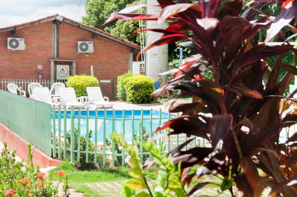 a house with a fence and chairs in a yard at Bonito HI Hostel e Pousada in Bonito
