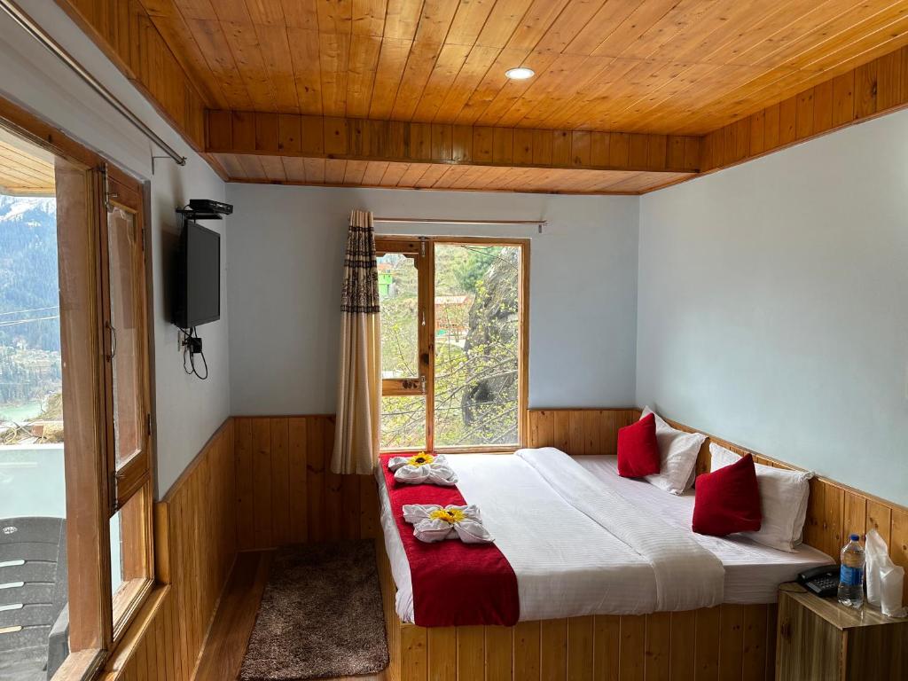 a bedroom with a bed with a window and a television at Hill Ice Guesthouse & Cafe - Mountain View & Balcony, Tosh in Tosh