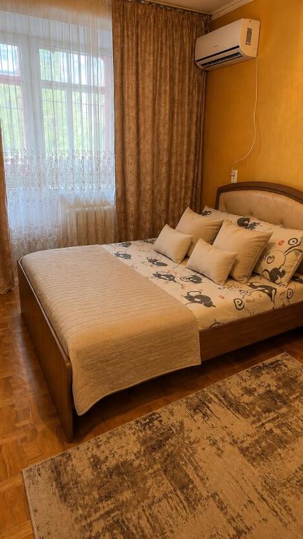 a bedroom with a large bed in a room at Economy - class apartment in Pavlodar