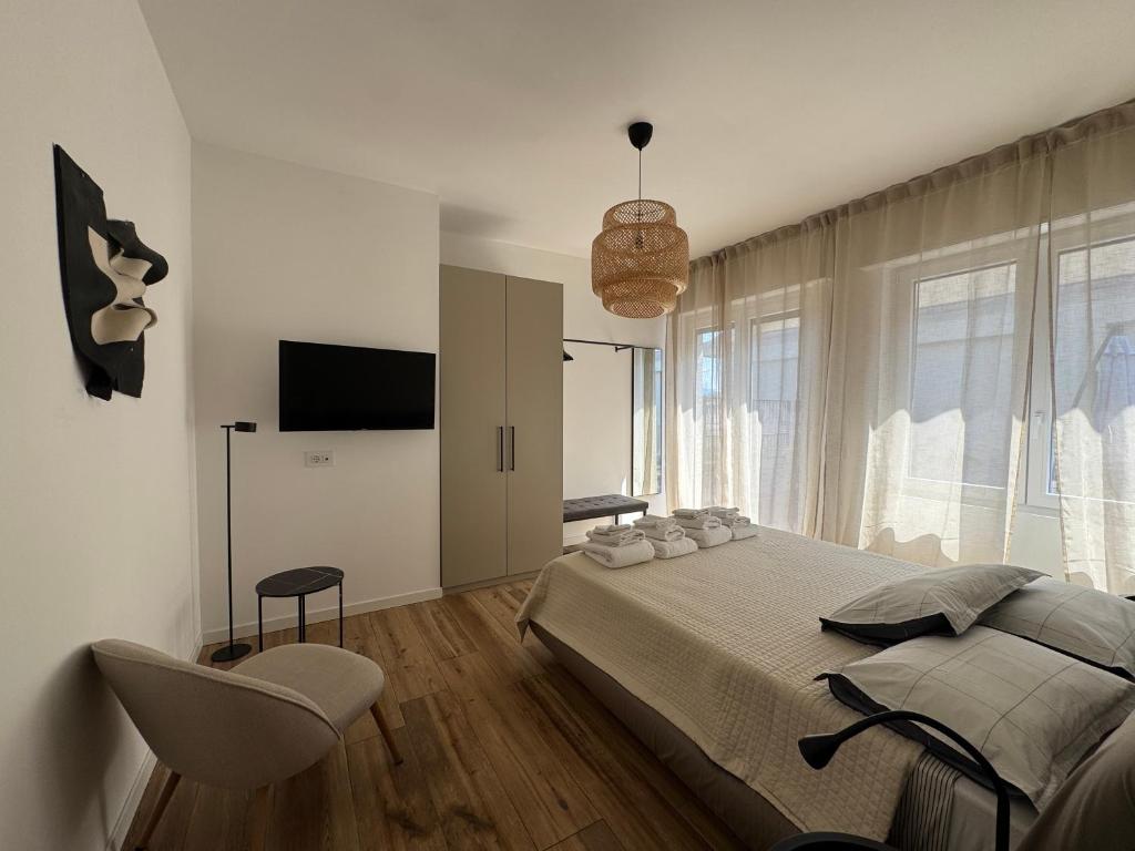a bedroom with a bed and a chair and a television at Alta Terrace - Warm Apartment with Large Terrace in Seriate