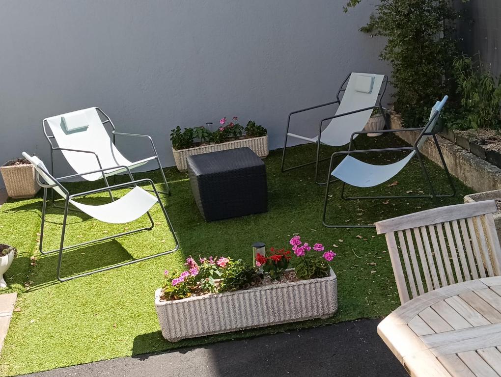 a group of chairs and flowers in a yard at Villa Mon Repos 3 in La Bourboule