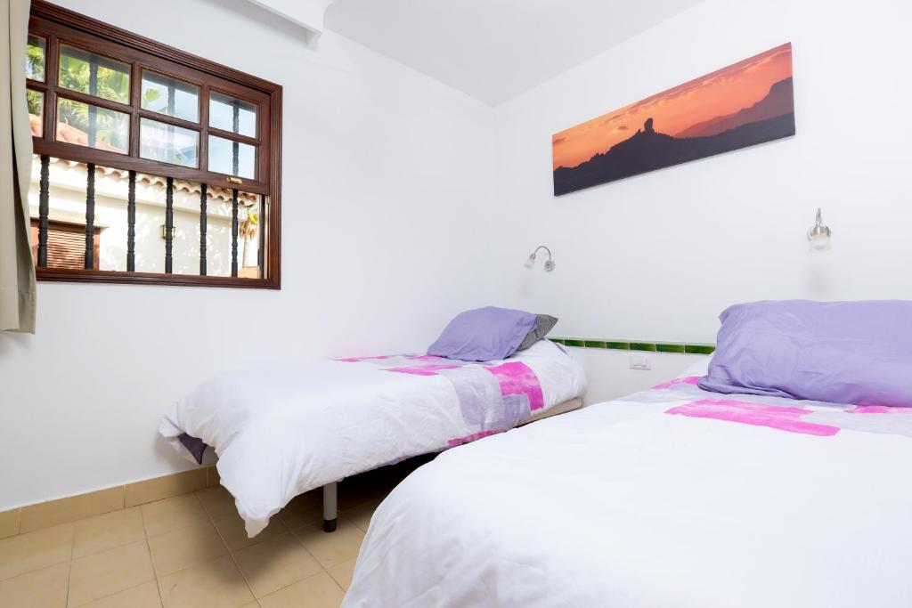 2 camas en una habitación con ventana en Sunny Bungalow Parque Golf en Maspalomas