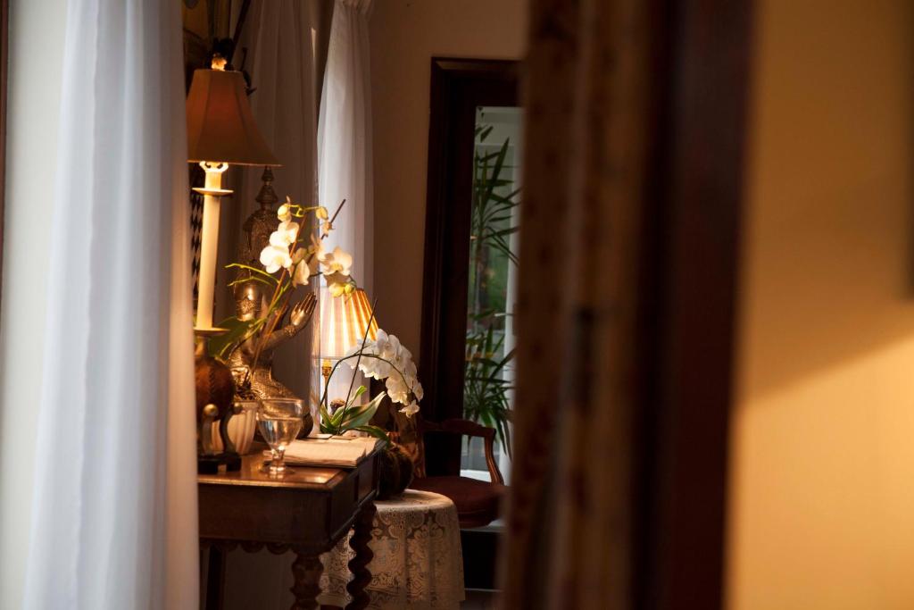 a room with a table with flowers and a lamp at The Lodge at Ruddington in Nottingham