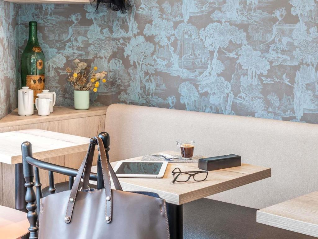 a table with a purse and glasses on a table with a table sidx sidx sidx at ibis Styles Sceaux Paris Sud in Sceaux