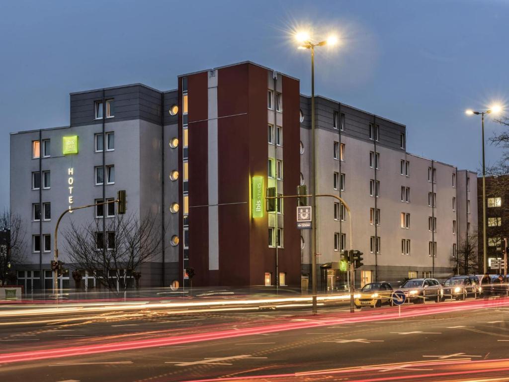 a building on a street with cars parked in front of it at ibis Styles Hotel Gelsenkirchen in Gelsenkirchen