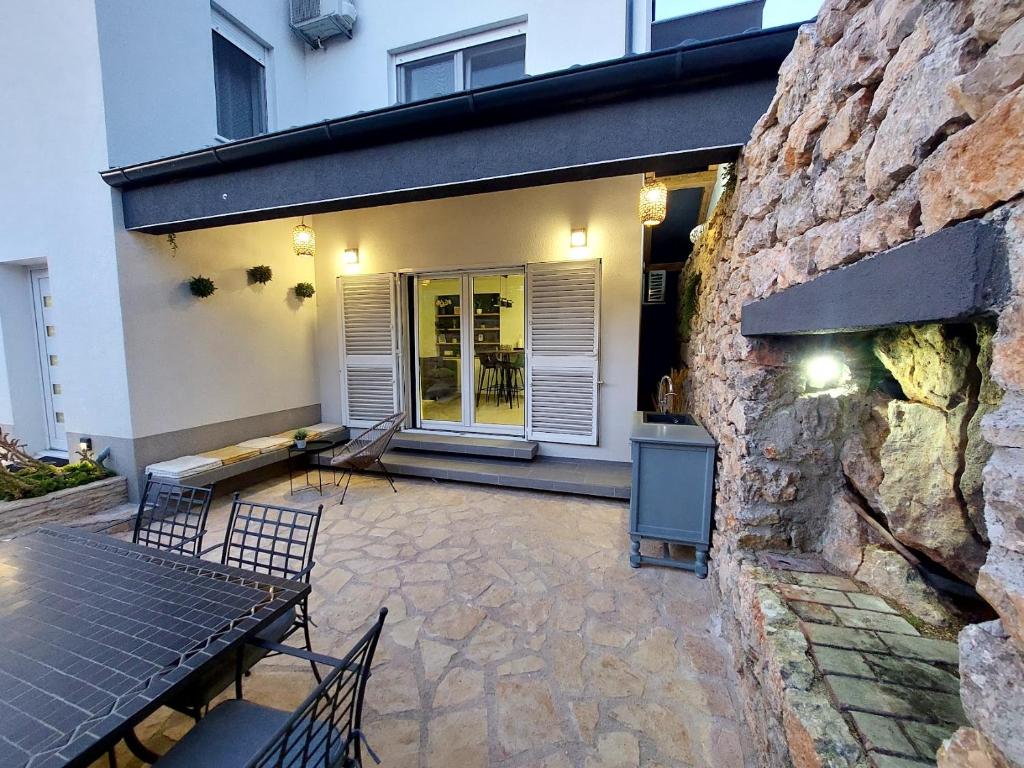 a patio with a table and chairs in front of a building at Apartman Zlatan in Drniš