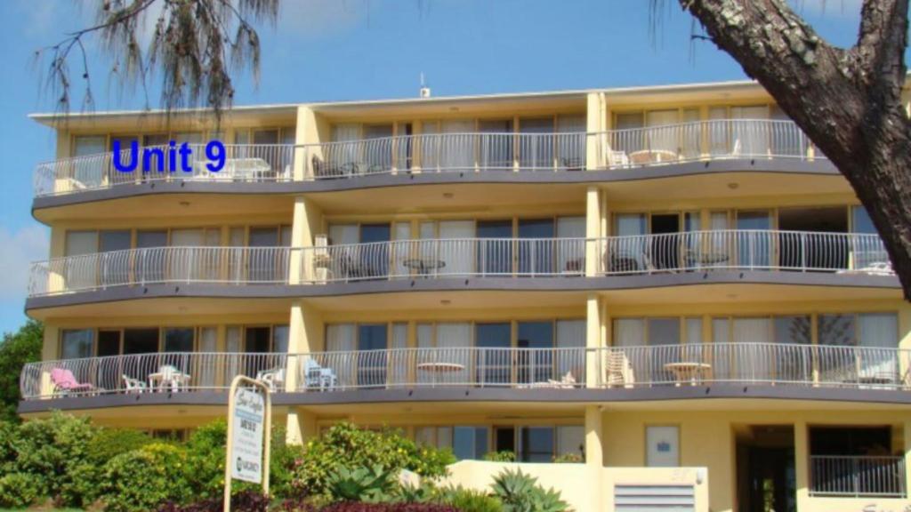a yellow building with a blue unit sign on it at Sea Eagles Unit 9 in Caloundra