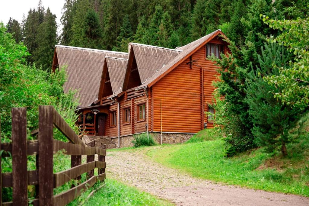 a wooden cabin with a fence in front of it at River Side Retreat in Slavske