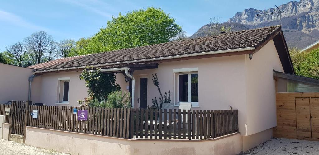 a small white house with a wooden fence at Gîte fabuleux, jardin, terrasse, parking in Saint-Vincent-de-Mercuze