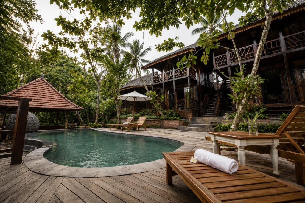 a resort with a pool and a house at The Campuhan Retreat in Munggu