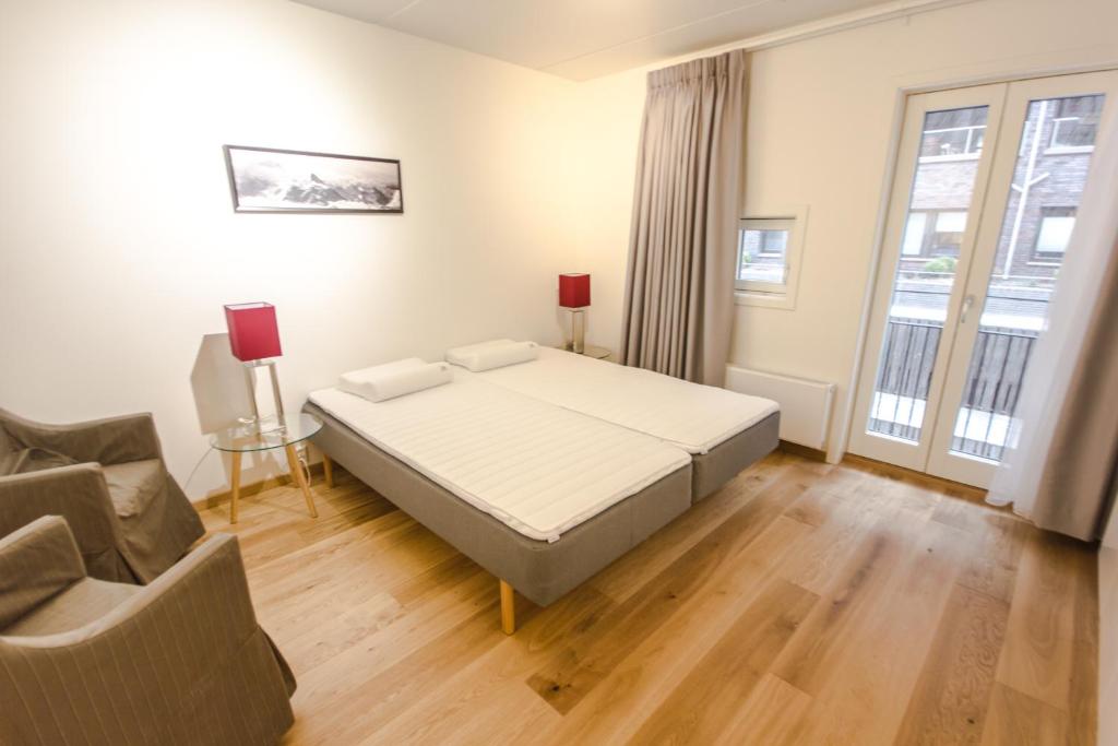 a bedroom with a bed and a chair and a couch at City Center Oslo- Venice Apartment Sea Side Three-Bedrooms and Two Toilettes in Oslo