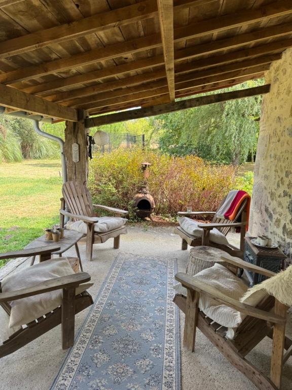 a patio with chairs and a table and a fireplace at Rimbes Casteljaloux - Gite 6 pers in Casteljaloux