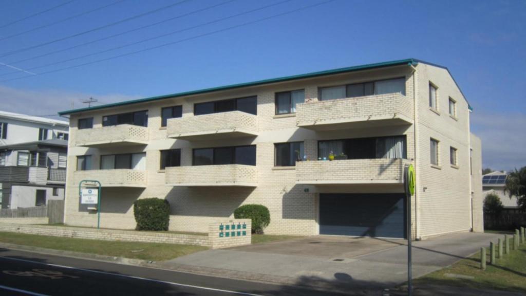 a white apartment building on the side of a street at Brighton Le Sands Unit 6 in Golden Beach