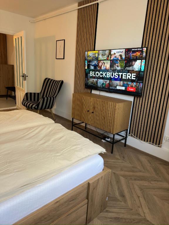 a bedroom with a bed and a flat screen tv at One Room Apartment- Self Check-in 24h in Reşiţa