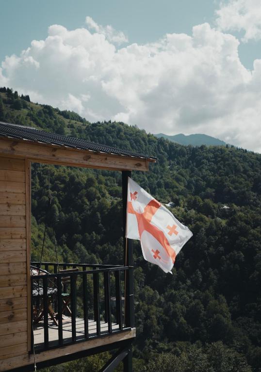 a flag hanging from the balcony of a cabin at Haiku Cottages in Merisi