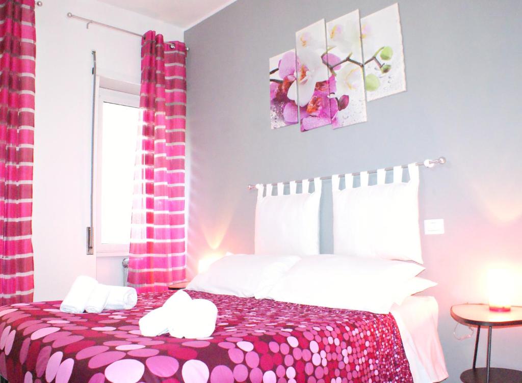 Un dormitorio con una cama rosa y blanca y una ventana en Like Family House, en Roma