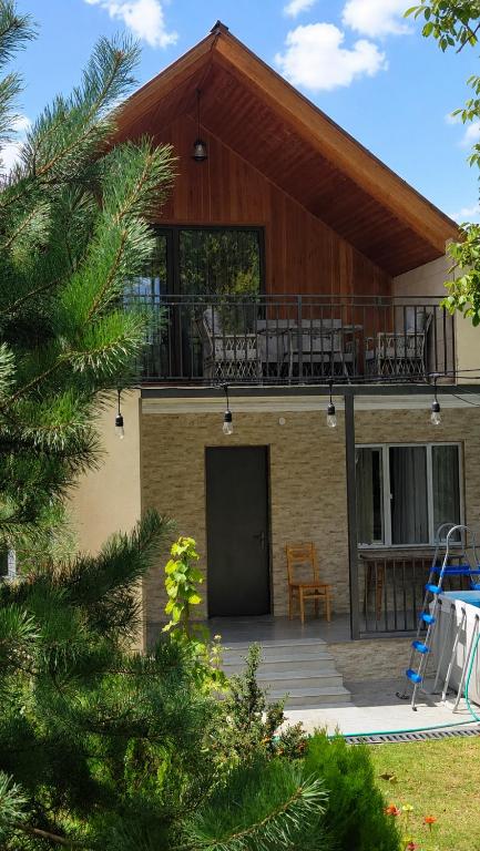 a house with a balcony and a deck at olya's garden in Tsʼageri