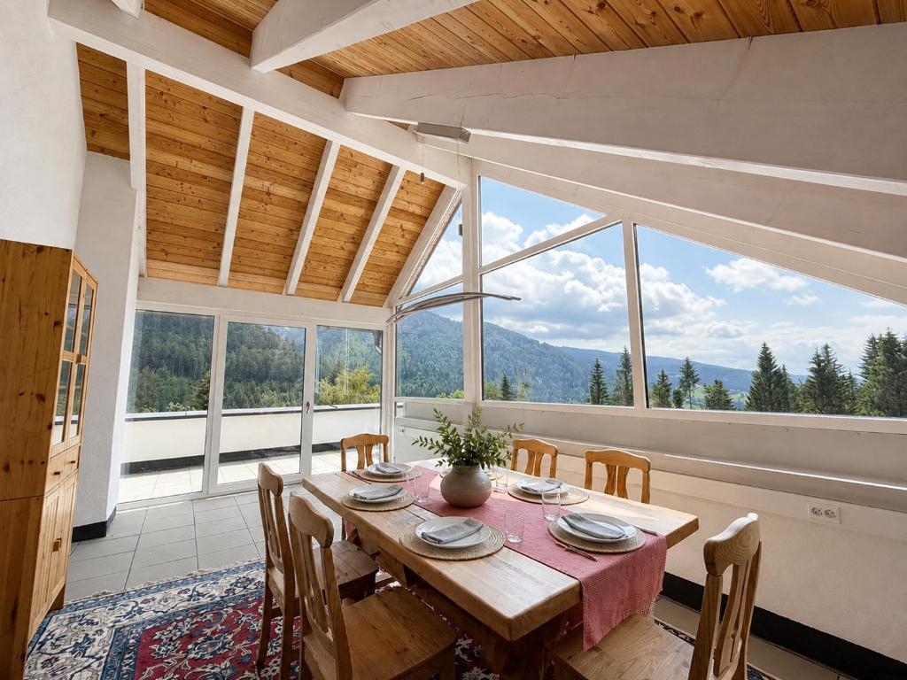 a dining room with a table and chairs and a large window at Bergzauber am Semmering in Semmering
