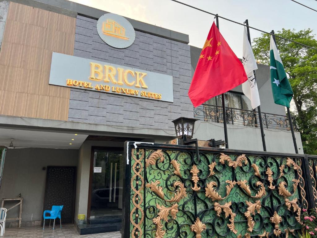 a building with two flags in front of it at brick hotel & luxury suites in Lahore