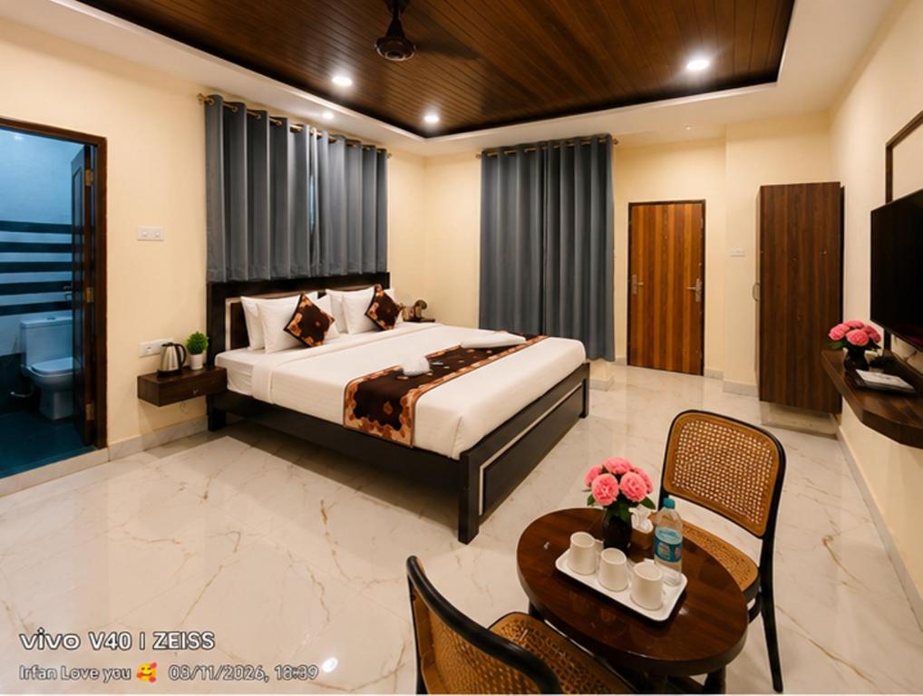a bedroom with a large bed and a table with a table at Hotel Sky Palace Airport Zone in Hyderabad